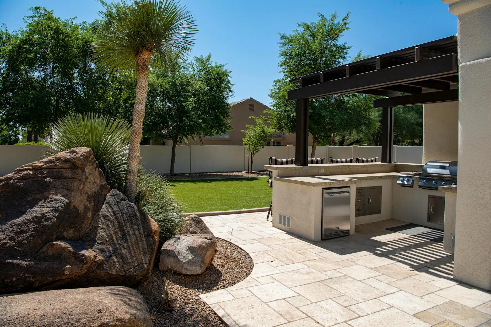 Upscale Gilbert backyard with mature landscaping and a manicured lawn — the Seville Golf & Country Club aesthetic where weekly pooper scooper service keeps premium yards usable